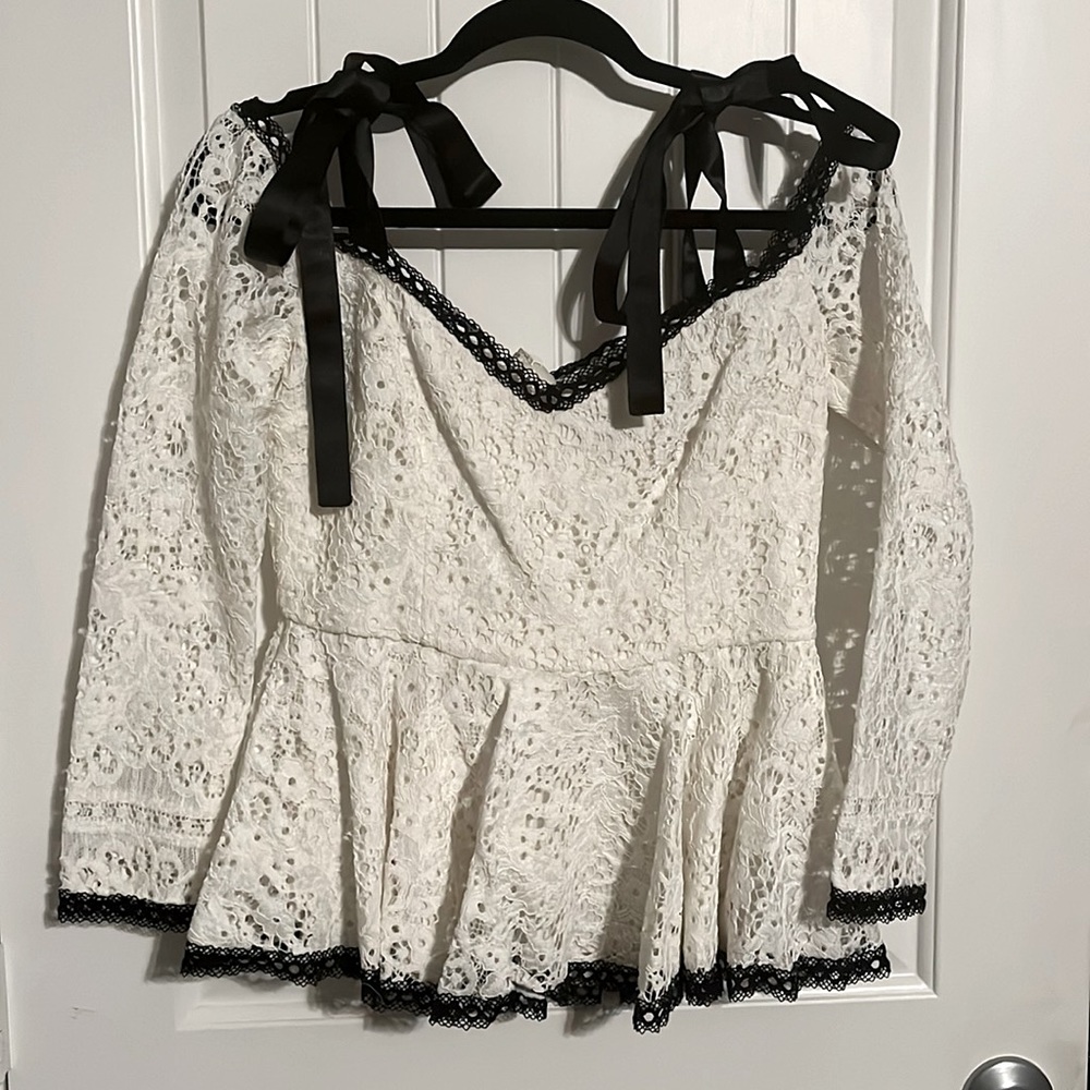 Alexis White lace with black trim peplum top with silk bow shoulder detail